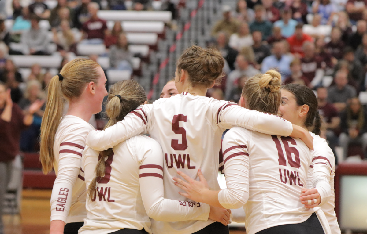 UWL volleyball huddles after a point. 